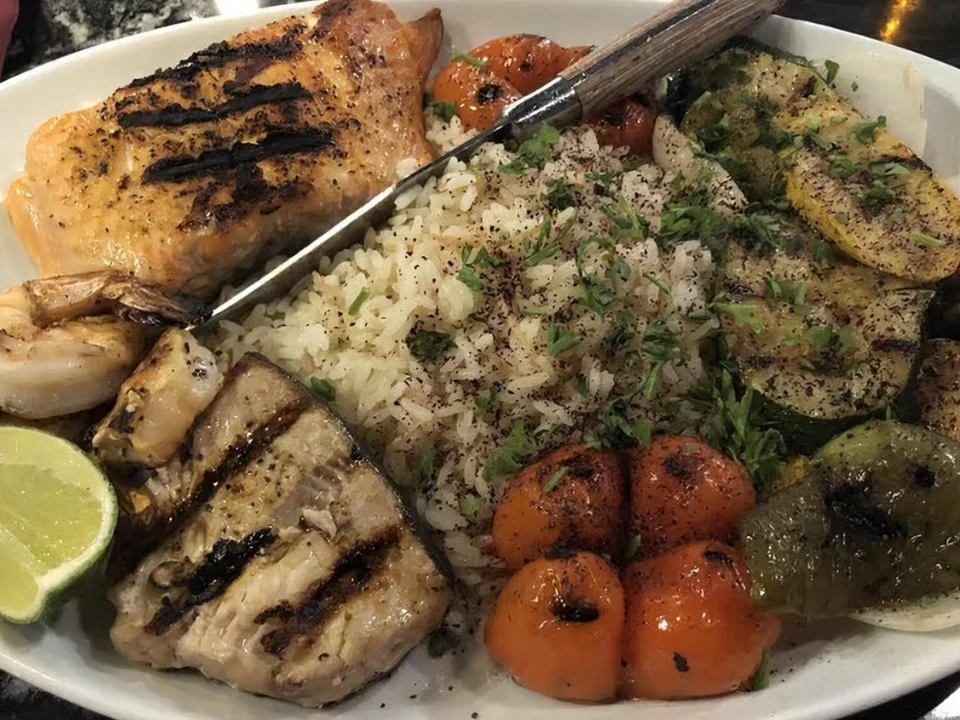 Kabob Mixed Grill - A generous platter of flame-grilled meats served with fragrant rice, grilled vegetables, and a squeeze of fresh lime.